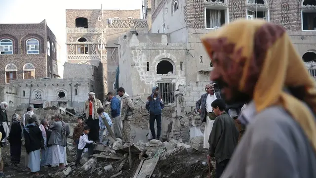 Warga berada di puing-puing sejumlah rumah yang dihantam koalisi Arab Saudi di dekat komplek Kementerian Pertahanan Yaman di Sanaa (11/11/2017).