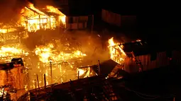 Warga berusaha memadamkan api dengan air saat kebakaran di lingkungan Educandos, di Manaus, Brasil (17/12). Para pihak berwenang mengatakan setidaknya 600 rumah kayu hanggus terbakar. (AP Photo/Edmar Barros)