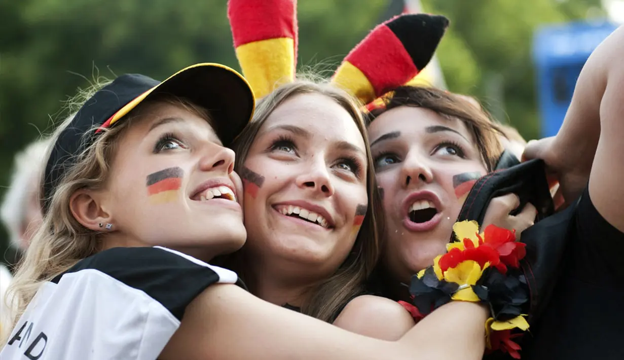 Beberapa suporter wanita Timnas Jerman berpelukan saat menyaksikan dan merayakan kemenangan Der Panzer atas Perancis 1-0 di Berlin, (4/7/2014). (REUTERS/Steffi Loos)