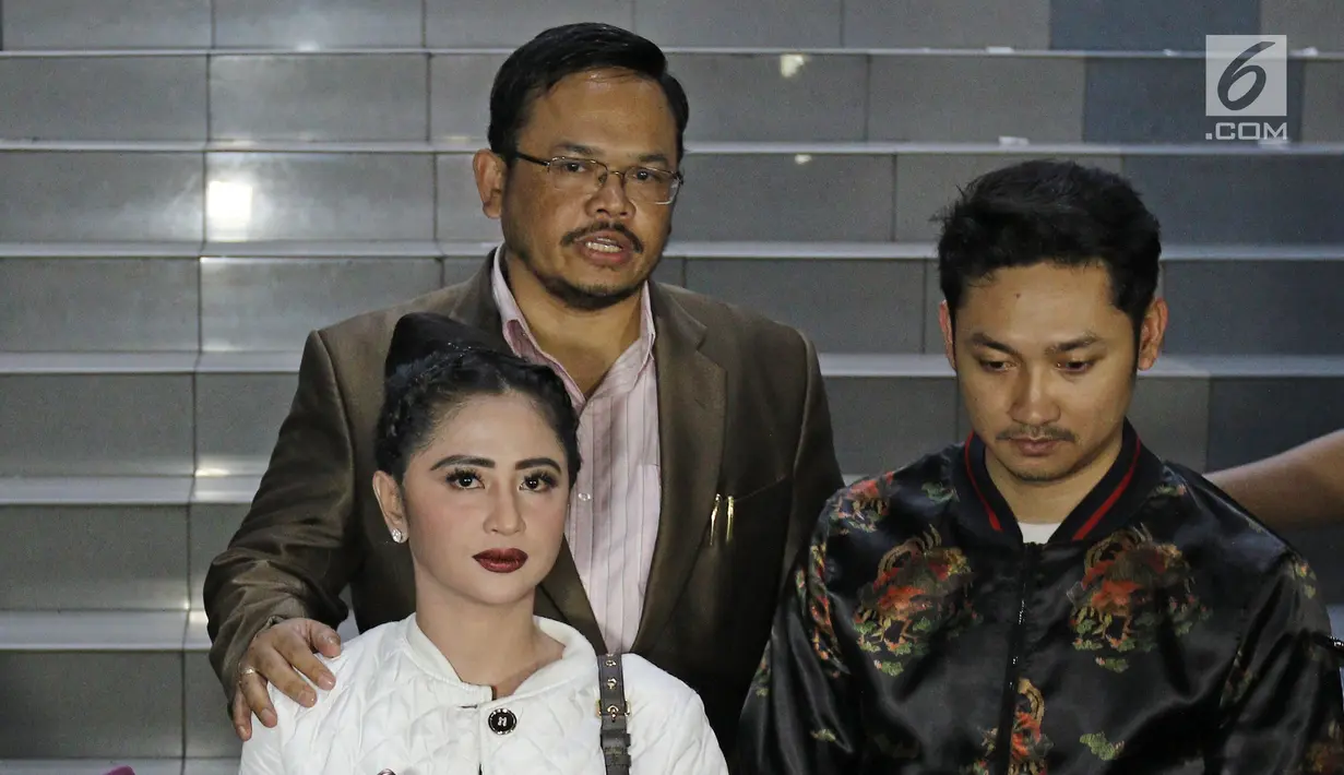 Dewi Persik didampingi suaminya, Angga Wijaya serta pengacara memberikan keterangan seusai membuat laporan di Polda Metro Jaya, Senin (4/12). Pihak Dewi Perssik melaporkan balik petugas Transjakarta, Harry Maulana Saputra (Liputan6.com/Herman Zakharia)