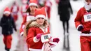 Seorang anak perempuan berpakaian Sinterklas mengambil bagian dalam Santa Claus Run di Pristina, Minggu (16/12). Ratusan pelari berpartisipasi dalam lomba lari amal untuk menggalang dana bagi keluarga yang membutuhkan di Kosovo. (Armend NIMANI/AFP)