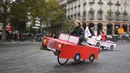 Sejumlah orang naik sepeda yang dihias kardus berbentuk mobil di Place de la Bastille, Paris, Prancis (1/10). Acara hari bebas kendaraan bermotor yang digelar pada 1 Oktober ini merupakan yang ketiga kalinya. (AFP Photo/Eric Feferberg)