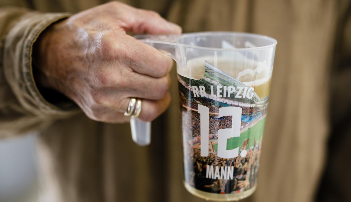 A man holding a beer cup is seen prior to the Bundesliga match between RB Leipzig and VfL Wolfsburg at Red Bull Arena on October 19, 2019 in Leipzig, Germany. (Photo by Reinaldo Coddou H./Bundesliga/Bundesliga Collection via Getty Images)