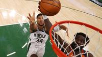 Giannis Antetokounmpo (kiri) memainkan peran vital pada kuarter terakhir ini. Dirinya berhasil memblok usaha Deandre Ayton (kanan) memasukkan bola, sehingga Suns gagal menyamakan kedudukan. Bucks akhirnya mengunci kuarter keempat dengan skor 33-21. (Foto: Getty Images via AFP/Pool/Mark J. Rebilas)