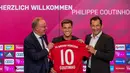 Pemain baru Bayern Munchen Philippe Coutinho (tengah) memegang jersey timnya bersama CEO Karl-Heinz Rummenigge (kiri) dan pelatih Hasan Salihamidzic saat konferensi pers di Munich, Jerman, Senin (19/8/2019). Coutinho resmi menjadi pemain Bayern Munchen musim 2019-2020. (Peter Kneffel/dpa via AP)