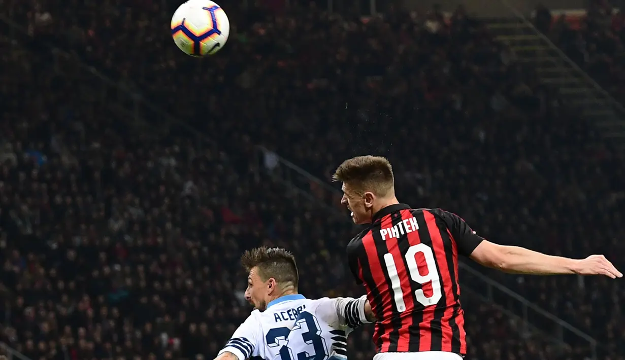 Striker AC Milan, Krzysztof Piatek berusaha menyundul bola dari kawalan bek Lazio, Francesco Acerbi selama pertandingan lanjutan Liga Serie A Italia di stadion San Siro (13/4). Milan menang tipis atas Lazio 1-0. (AFP Photo/Miguel Medina)