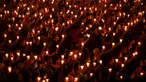 Umat Kristen memegang lilin saat ibadah malam Natal di Gereja Bethany, Surabaya, Jawa Timur, Minggu (24/12/2023). Pelaksanaan ibadah malam Natal berjalan aman dan lancar. (Juni KRISWANTO/AFP)