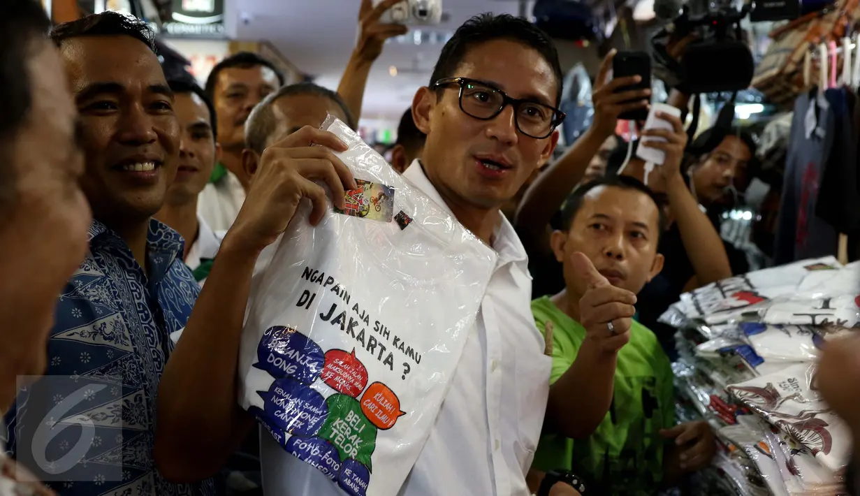 Cawagub DKI Jakarta, Sandiaga Uno membeli kaus bertuliskan I Love Jakarta saat menyambangi ITC Mangga Dua, Jakarta Utara, Kamis (3/11). Kedatangan Sandiaga disambut meriah pedagang dan pengunjung pusat perbelanjaan tersebut. (Liputan6.com/Gempur M Surya)