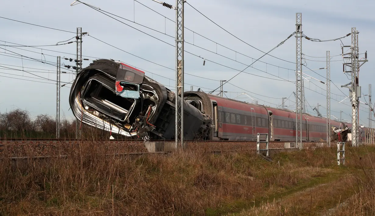 Sebuah gerbong kereta tergeletak di sisinya setelah tergelincir di dekat Lodi, Italia utara, Kamis (6/2/2020). Jalur kereta yang terlibat kecelakaan kemudian ditutup di kedua arah, memaksa kereta jam sibuk untuk mengambil rute yang lebih lambat. (AP/Antonio Calanni)