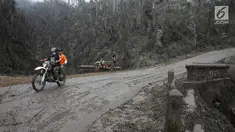 Relawan penyelamat hewan melintas di kawasan radius 3 km dari puncak Gunung Agung di Desa Sebudi, Karangasem, Bali, Senin (4/12). Erupsi Gunung Agung menyebabkan kawasan dalam radius terdampak mengalami kerusakan. (Liputan6.com/Immanuel Antonius)