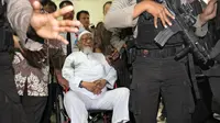 Terpidana kasus terorisme Abu Bakar Baasyir dikawal aparat kepolisian ketika tiba dengan kursi roda untuk menjalani operasi katarak di Jakarta, (29/02/2012). (AFP Photo/Romeo Gacad)