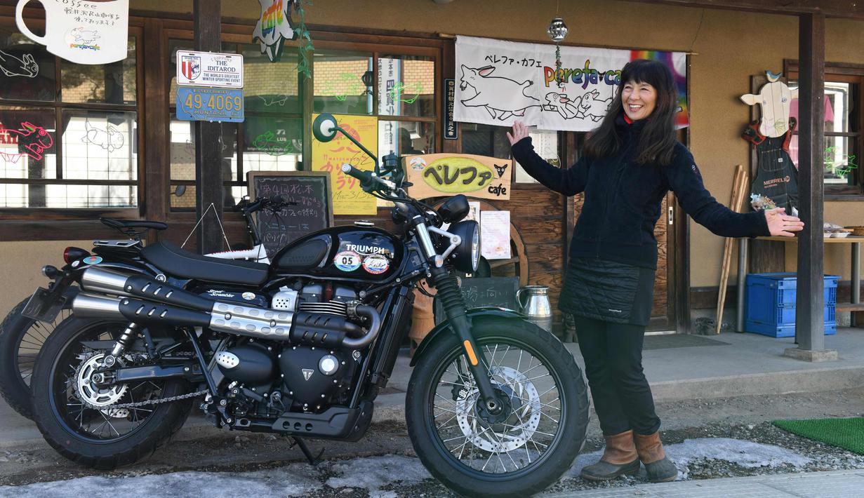 Reiko Miyoshi (60) berpose di samping motor Triumph Street Scrambler miliknya di luar "Perefa Cafe" di Matsumoto, prefektur Nagano (23/2). Pada 1976, ia mengelilingi Jepang dengan motor Suzuki Hustler TS250 selama 365 hari. (AFP Photo/Toshifumi Kitamura)