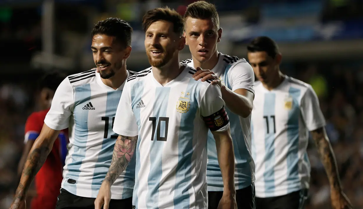 Lionel Messi berjalan bersama rekan setimnya usai mencetak hattricknya saat pertandingan persahabatan melawan Haiti di stadion Bombonera di Buenos (29/5). (AP / Natacha Pisarenko)