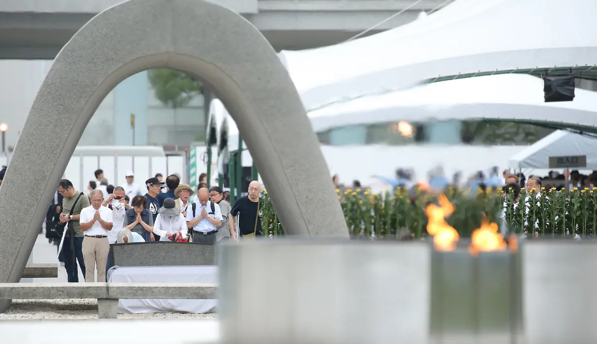 Orang-orang berdoa untuk para korban bom atom di Hiroshima Peace Memorial Park, pusat kota Hiroshima, Jepang, Selasa (5/8/2019). Pemerintah Jepang menggelar peringatan jatuhnya bom atom di Kota Hiroshoma 74 tahun lalu yang menandai berakhirnya Perang Dunia (PD) II. (JIJI PRESS / AFP)