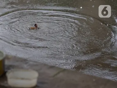 Anak-anak berenang di Sungai Ciliwung, Rawajati, Jakarta, Selasa (17/12/2019). Meski debit air Sungai Ciliwung naik akibat hujan mengguyur Jakarta sejak siang hingga sore, anak-anak tersebut tetap nekat berenang tanpa memedulikan keselamatan. (Liputan6.com/Immanuel Antonius)