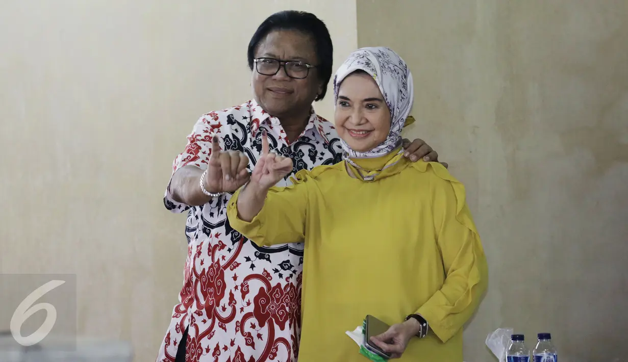 Ketua DPD RI Oesman Sapta Odang atau Oso di dampingi Istri Serviati Oesman menunjukan jarinya usai menggunakan hak pilihya dalam Pilkada Putaran kedua di TPS 03 Denpasar, Kuningan Timur, Jakarta, Rabu (19/4). (Liputan6.com/Johan Tallo)