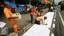 Juru parkir melakukan aksi menandatangani kain putih di jalan Malioboro,Yogyakarta, Jumat (11/3). Dalam aksinya mereka meminta dukungan kepada pengguna jalan yang melintas dan menuntut kejelasan relokasi yang bernurani. (Liputan6.com/Boy Harjanto)