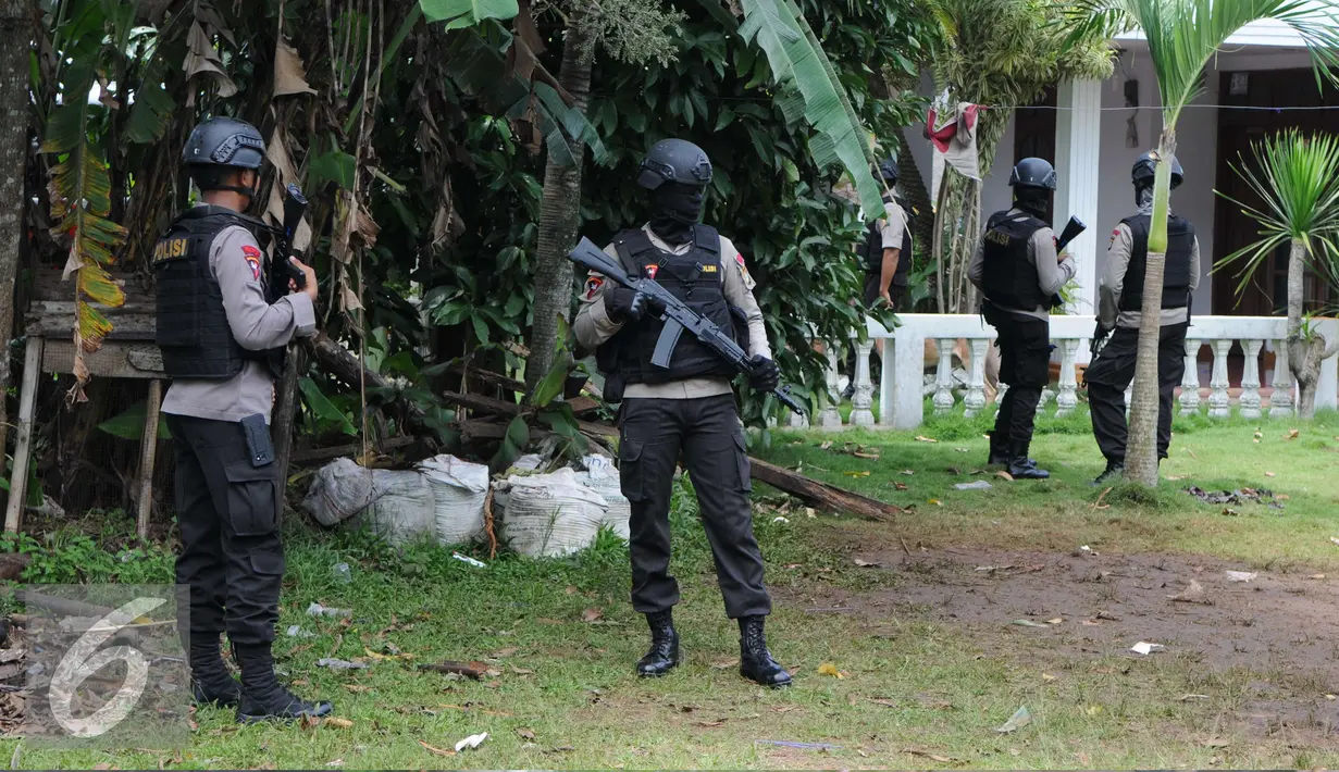 Petugas Kepolisian Brimob berjaga disekitar area rumah terduga teroris di Setu, Tangerang Selatan, Rabu (21/12). Penggerebekan bermula ketika Densus menangkap terduga teroris berinisial AN di Jalan Raya Serpong. (Liputan6.com/Helmi Affandi)