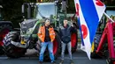 Dua petani berdiri dekat traktor di Benoordenhoutseweg, Den Haag, Belanda, Rabu (16/10/2019). Para petani mengkritik kebijakan pemerintah untuk memerangi perubahan iklim. (Remko de Waal/ANP/AFP)