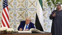 Presiden Amerika Serikat Donald Trump menandatangani buku tamu didampingi Presiden Uni Emirat Arab Mohammed bin Zayed Al Nahyan, Kamis (15/5/2025), di Abu Dhabi. (Dok. AP/Alex Brandon)