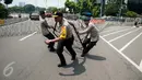 Polisi memasang kawat berduri saat peringatan May Day di depan Istana Negara, Jakarta, Senin (1/5). Kawat berduri dipasang untuk mengantisipasi puluhan ribu buruh yang akan menggelar aksi unjuk rasa di Istana Negara. (Liputan6.com/Gempur M Surya)