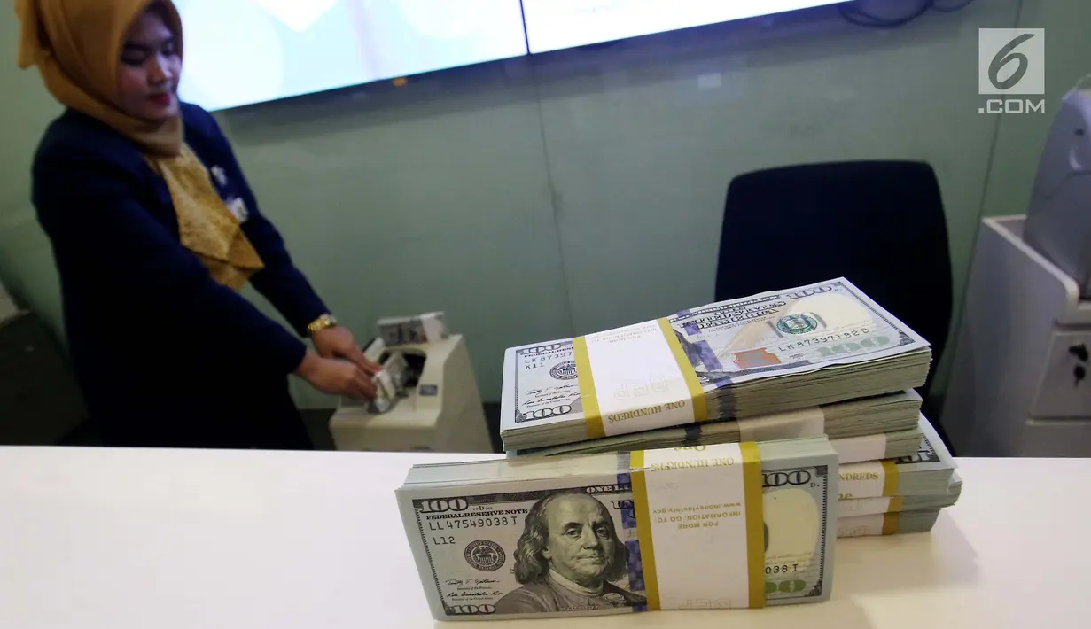 Petugas bank menghitung uang dollar AS di Jakarta, Jumat (20/10). Nilai tukar Rupiah terhadap Dolar Amerika Serikat (USD) masih belum beranjak dari level Rp 13.500-an per USD. (Liputan6.com/Angga Yuniar)