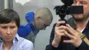 <p>Tentara Rusia, Sersan Vadim Shishimarin (21) terlihat di balik kaca selama sidang pengadilan di Kiev, Ukraina, Rabu (18/5/2022). Sersan Vadim Shishimarin dapat terancam hukuman seumur hidup karena membunuh warga sipil Ukraina berusia 62 tahun di desa Chupakhivka, Ukraina timur laut pada 28 Februari. (AP Photo/Efrem Lukatsky)</p>