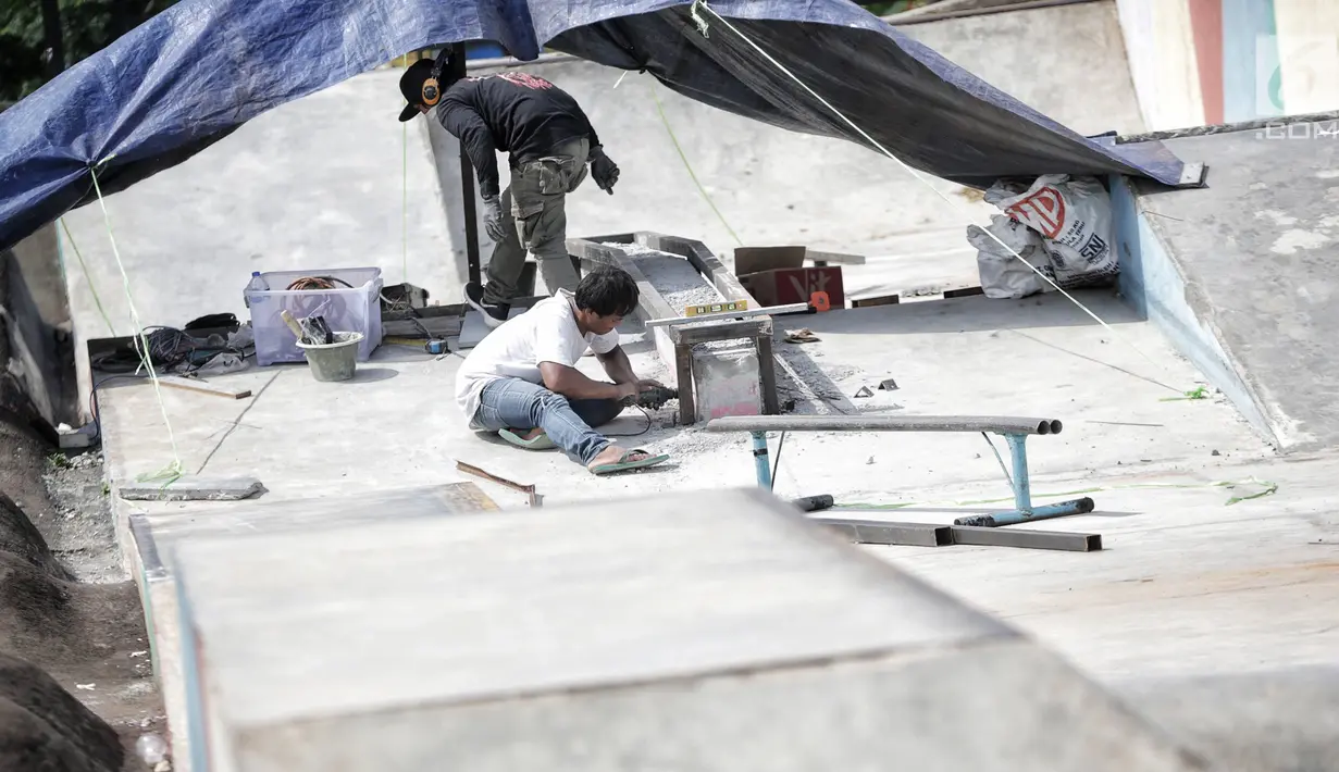 Pekerja memperbaiki arena skateboard yang rusak di RPTRA Kalijodo, Jakarta, Kamis (24/1). Perbaikan dilakukan untuk membuat rasa aman dan nyaman pengunjung yang menggunakan arena tersebut. (Liputan6.com/Faizal Fanani)