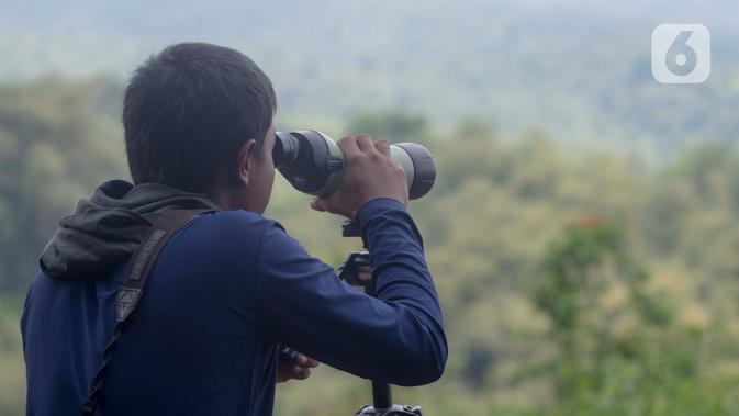 Petugas Pusat Suaka Elang Jawa (PSSEJ) memonitor pergerakan burung elang lainnya melalui kamera DSLR di area pelepasan burung Elang Brontok (Nisaetus Cirrhatus). (merdeka.com/Imam Buhori)