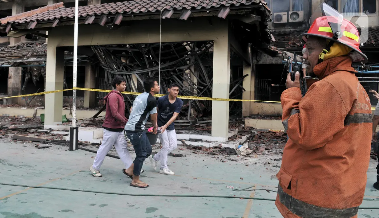 Siswa mengangkut bak air saat berusaha memadamkan api yang kembali muncul di Gedung SMK Yadika 6, Jatiwaringin, Pondok Gede, Kota Bekasi, Jawa Barat, Selasa (19/11/2019). Api muncul di salah satu ruang yang berada di lantai 2. (merdeka.com/Iqbal Nugroho)