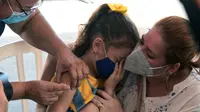 Petugas kesehatan menyuntik vaksin covid-19 kepada seorang anak di San Lorenzo, Paraguay, Senin (31/1/2022). Paraguay mulai memvaksinasi anak-anak berusia 5 hingga 11 tahun pada hari Senin, karena peningkatan tajam infeksi covid-19 yang didorong oleh varian omicron. (NORBERTO DUARTE / AFP)