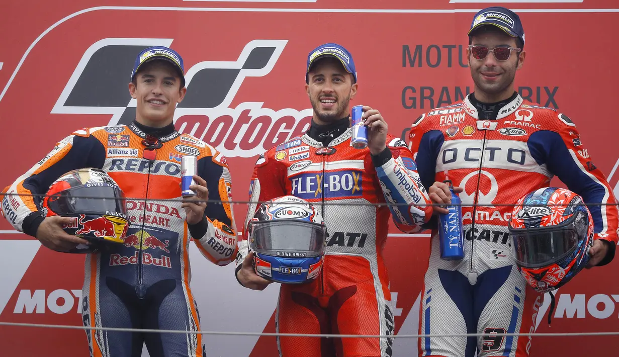 Pebalap Andrea Dovizioso bersama Marc Marquez dan Danilo Petrucci berpose usai balapan MotoGP Jepang di Sirkuit Motegi, Minggu (15/10/2017). Andrea Dovizoso menyelesaikan balapan dengan catatan waktu 47 menit 14,236 detik. (AP/Shizuo Kambayashi)