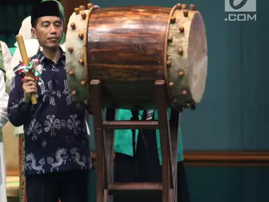 Presiden Joko Widodo atau Jokowi memukul bedug saat membuka Harlah ke-93 NU di Jakarta, Kamis (31/1). Jokowi didampingi sejumlah menteri Kabinet Kerja saat menghadiri Harlah ke-93 NU. (Liputan6.com/Angga Yuniar)