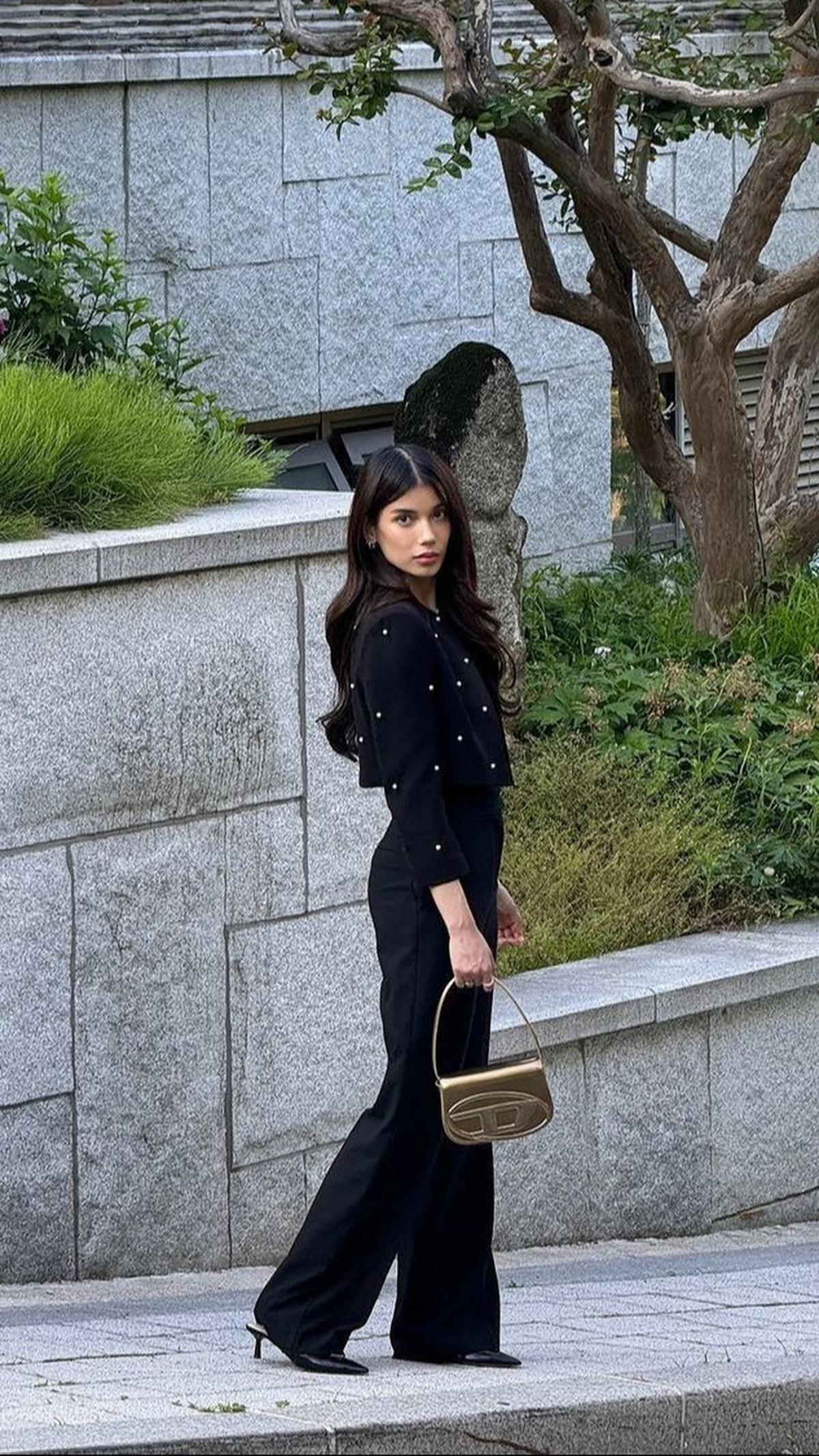 Dalam rumah The Queen's dari serial QUEEN OF TEARS, Sabrina berdiri dengan penuh pesona dalam busana hitam, menyerupai gaya Hong Hae-In. Kecantikannya seolah memancarkan aura yang sama dengan para pebisnis dalam drama tersebut.<br>