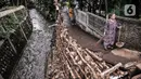 Warga beraktivitas di dekat turap longsor di Batu Ampar, Kramat Jati, Jakarta, Selasa (23/2/2021). Turap kali sepanjang 30 meter di permukiman RT 17 dan 13 RW 02 Kelurahan Batu Ampar longsor pada Sabtu (20/2) akibat derasnya arus air ketika aliran Kali Ciliwung meluap. (merdeka.com/Iqbal S. Nugroho)