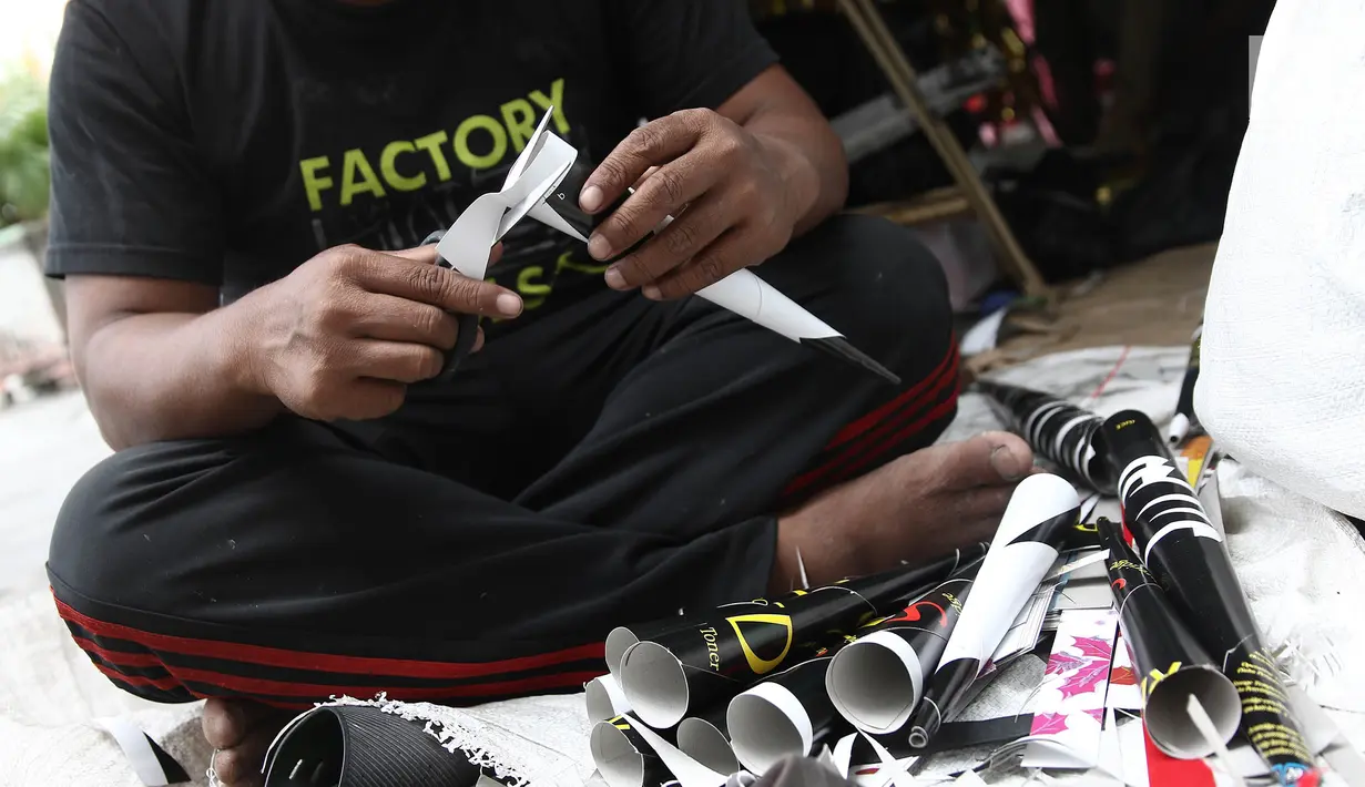 Pengrajin menyelesaikan pembuatan terompet di kawasan Glodok, Jakarta, Selasa (25/12). Menjelang tahun baru terompet konvensional tersebut dijual dengan harga dari Rp 5000 hingga Rp 10.000 tergantung ukuran dan jenisnya. (Liputan6.com/Herman Zakharia)