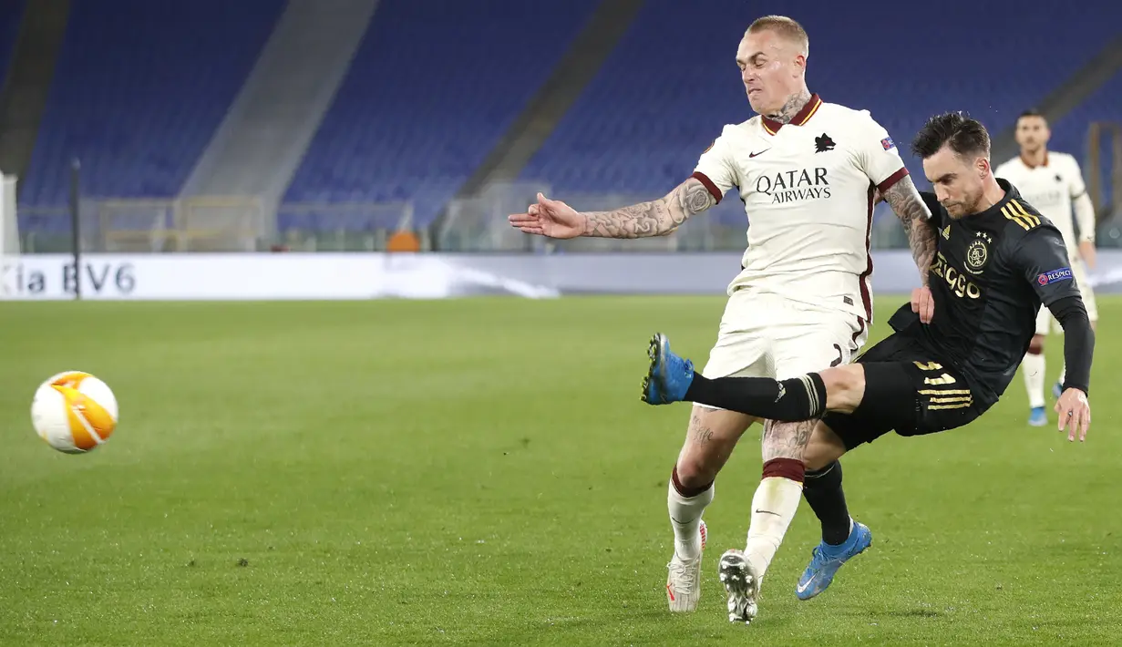 Bek AS Roma, Roger Ibanez dan penyerang Ajax Amsterdam, Dusan Tadic bersaing pada leg kedua perempat final Liga Europa di Olimpico, Jumat (16/4/2021) dini hari WIB. AS Roma melaju ke semifinal Liga Europa musim ini setelah bermain imbang 1-1 lawan Ajax. (AP Photo/Alessandra Tarantino)