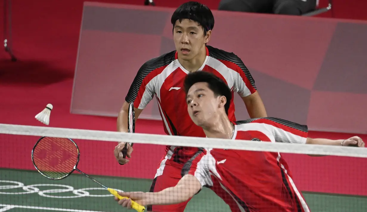 Ganda putra Indonesia Kevin Sanjaya Sukamuljo (depan) dan Marcus Gideon melawan Ben Lane dan Sean Vendy dari Inggris pada pertandingan ganda putra Grup A Olimpiade Tokyo  2020 di Musashino Forest Sports Plaza, Sabtu (24/7/2021). Kevin / Marcus menang 21-15, 21-11. (Alexander NEMENOV/AFP)