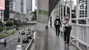 Pekerja melintasi jembatan penyeberangan orang saat jam pulang kantor di kawasan Sudirman, Jakarta, Senin (14/9/2020). Pengurangan aktivitas pekerja di perkantoran menjadi fokus utama Pemprov DKI Jakarta dalam penerapan PSBB pada 14-27 September 2020. (merdeka.com/Iqbal S. Nugroho)