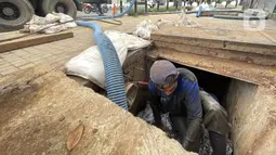 Petugas Dinas Tata Air Jakarta Selatan melakukan pengerukan endapan lumpur di gorong-gorong saluran air kawasan Blok M, Jakarta Selatan, Rabu (1/12/2021). Pengerukan dilakukan untuk mengantisipasi banjir di kawasan tersebut selama musim hujan. (Liputan6.com/Johan Tallo)