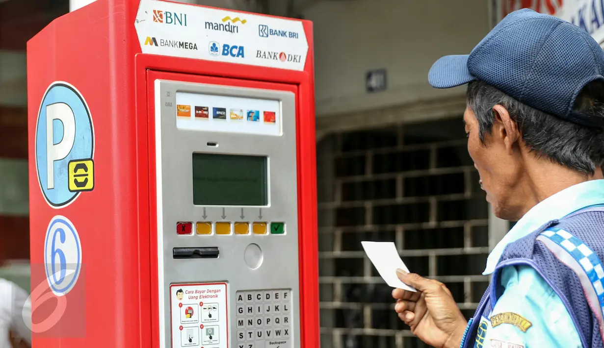 Petugas parkir melakukan transaksi dengan mesin terminal parkir elektronik (TPE) di jalan Sabang, Jakarta, Kamis (25/2). Pemprov DKI Jakarta berencana menambah mesin terminal parkir elektronik (TPE) atau parkir meter. (Liputan6.com/Yoppy Renato)