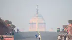 Orang-orang berjalan di dekat istana kepresidenan di tengah kondisi kabut asap tebal di New Delhi (15/11/2021). Otoritas kota New Delhi tengah mempertimbangkan penguncian wilayah akibat kian memburuknya polusi udara. (AFP/Money Sharma)