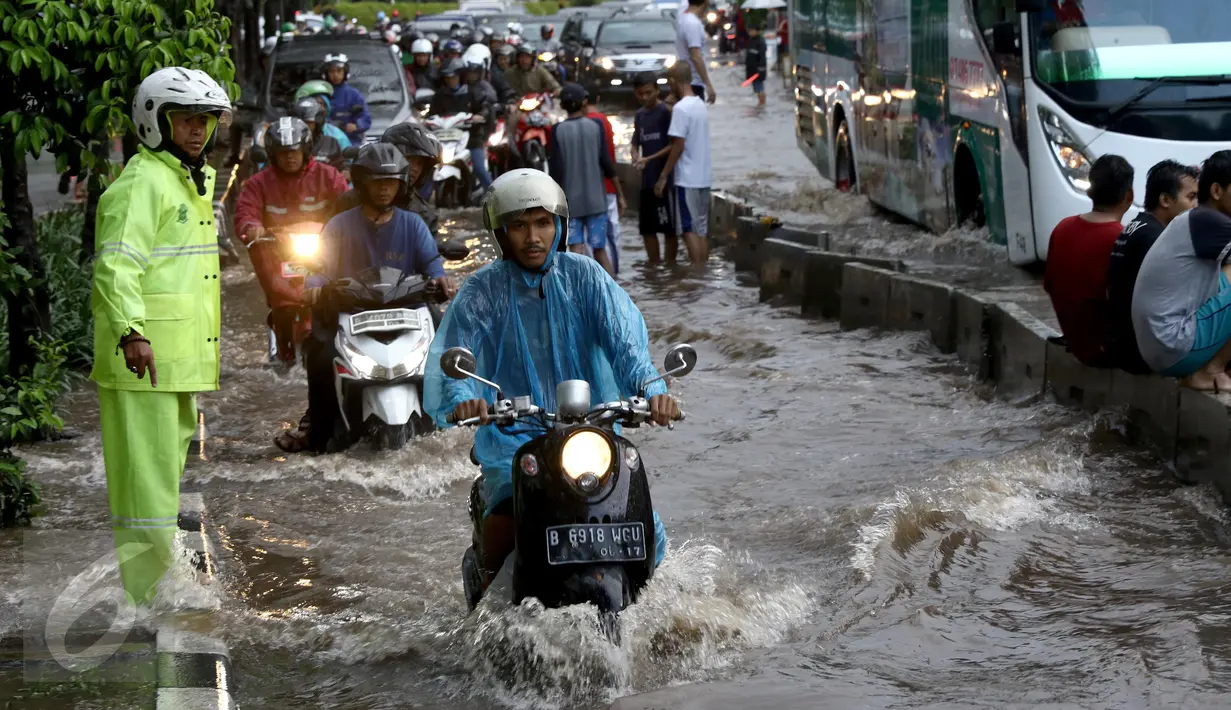 Polisi lalu lintas mengatur kendaraan yang melintas akibat banjir di depan Mall Gandaria City, Jakarta, Sabtu (27/8). Hujan intensitas tinggi membuat jalan tersebut banjir setinggi 30-50 cm. (Liputan6.com/Helmi Afandi)