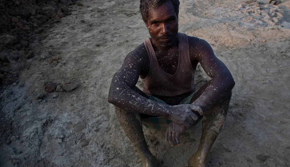 Pekerja India Suleiman, 36 tubuhnya terkena tanah saat beristirahat di sebuah pabrik batu bata di pinggiran Gauhati, India (22/11). Sebagian besar buruh di sini mendapatkan Rupee 120 (kurang dari 2 Dolar) per hari. (AP Photo/Anupam Nath)