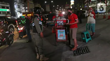 Petugas mensosialisasi aturan jam malam di sepanjang Jalan Margonda, Depok, Senin (31/8/2020). Sosialisasi aturan jam malam dilakukan selama 3 hari di kawasan Depok yang diberlakukan mulai malam hari ini guna meminimalisir penyebaran covid-19. (Liputan6.com/Herman Zakharia)