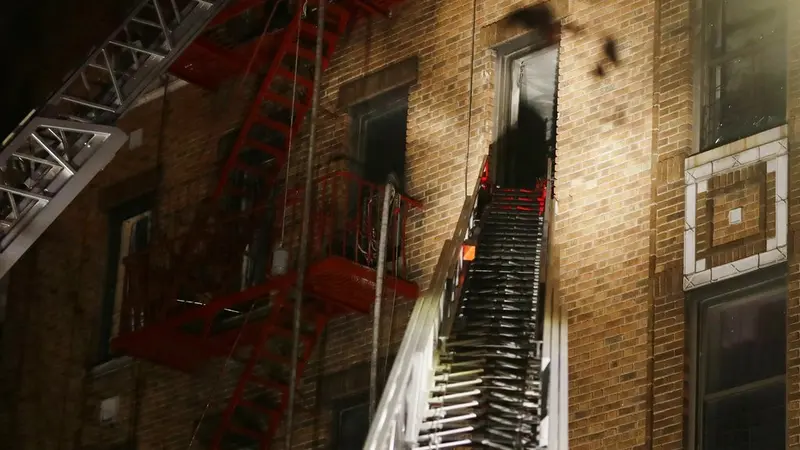 Pemadam kebakaran saat melakukan evakuasi setelah kebakaran terjadi sebuah apartemen lima lantai di Bronx, New York