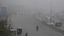 Kendaraan melaju di sebuah jalan di tengah kabut tebal di Kota Lahore, Pakistan timur, pada 13 Desember 2020. Kabut tebal menyelimuti sejumlah kota di Pakistan, sehingga meminimalkan jarak pandang dan mengganggu lalu lintas jalan. (Xinhua/Sajjad)