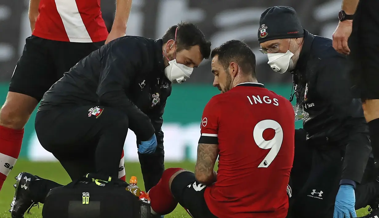 Striker Southampton, Danny Ings, mendapat perawatan sebelum akhirnya meninggalkan lapangan karena cedera dalam laga lanjutan Liga Inggris pekan ke-14 melawan Manchester City di St. Mary's Stadium, Southampton, Sabtu (19/12/2020). Southampton kalah 0-1 dari Manchester City. (AFP/Paul Childs/Pool)