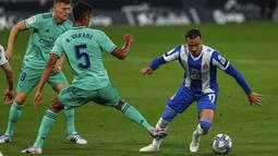 Pemain Espanyol, Raul de Tomas, berusaha melewati pemain Real Madrid, Raphael Varane, pada laga La Liga di Stadion Cornella-El Prat, Minggu (28/6/2020). Real Madrid menang 1-0 atas Espanyol. (AP/Joan Monfort)