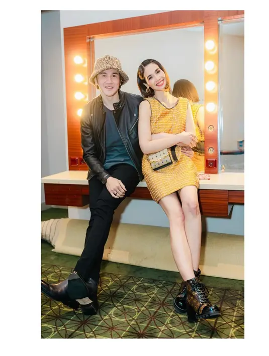 Dalam foto ini, Vino dan Marsha tampil dengan outfit bak ABG. Vino mengenakan kaus biru yang dilapisinya dengan jaket kulit hitam, dan celana panjang hitam. Sedangkan Marsha Timothy memilih mengenakan dress pendek tanpa lengan berwarna kuning yang sederhana, dengan sling bag dan midi heels boots hitam dari kulit. Foto: Instagram.